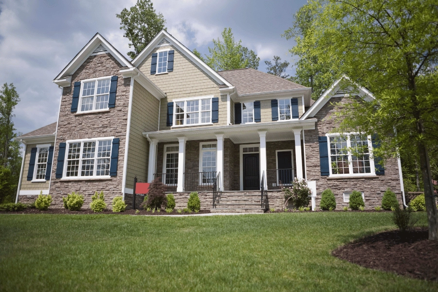 large single-family home with front porch, lots of windows, and well-maintained front yard